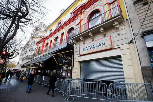 People walk past the Bataclan concert hall in Paris on December 22 after the sidewalk in front of the venue was once again made accessable to...