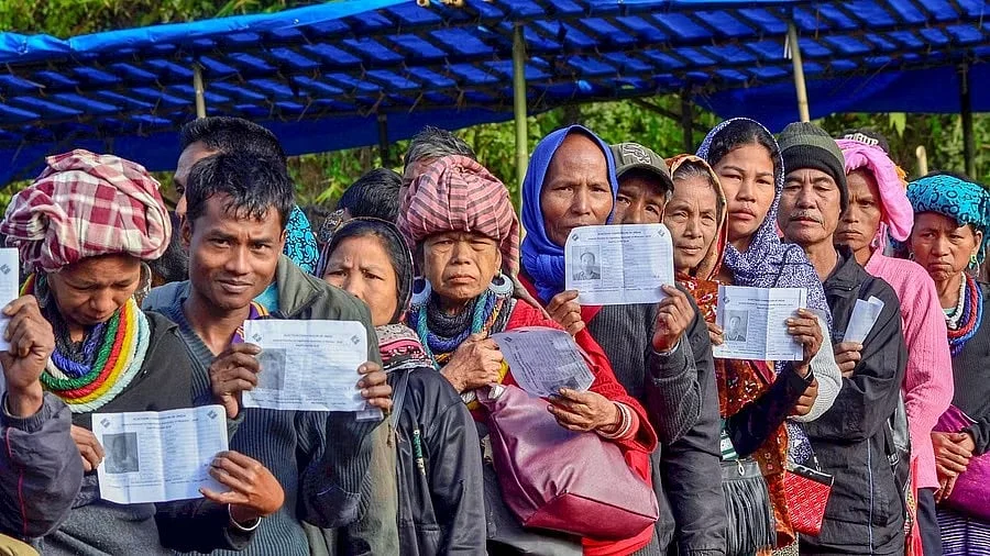 <div class="paragraphs"><p>Voters show their identity card as they stand in a queue at a polling station during the state Assembly elections, at Kanhmun, Mizoram.</p></div>