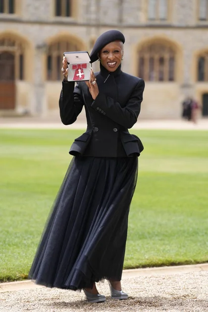 Cynthia Erivo wearing custom Givenchy by Sarah Burton at her MBE investiture ceremony at Windsor Castle.
Cynthia Erivo posing with her MBE medal in a black tailored Givenchy look at Windsor Castle.