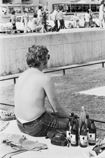 Canicule sur l'Europe - A Paris, on essaie de lutter contre la vague de chaleur. Ici, un homme assis, torse nu. A côté de lui, plusieurs bouteilles...