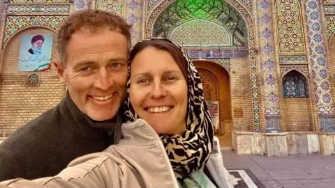 Facebook/ drlindsayforeman Selfie showing Lindsay and Craig Foreman outside a mosaic building.
