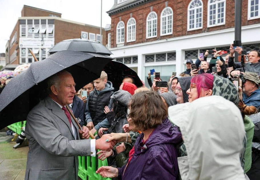 Britain's King Charles III greets well-wishers who had waited in the rain in the hope of meeting him, during his visit to Grimsby