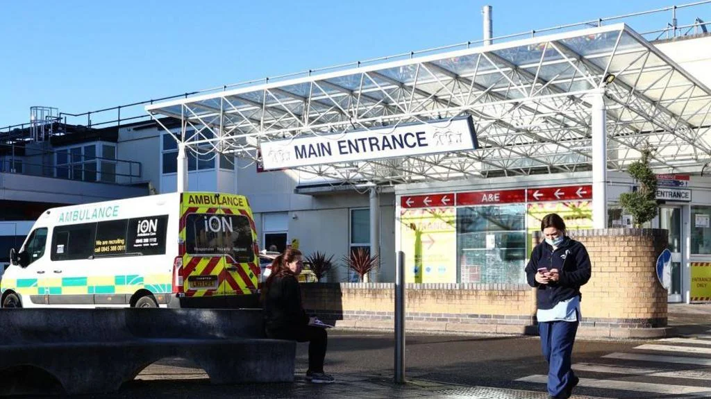 A member of the hospital personnel walks outside the Frimley Park Hospital in Surrey on January 13, 2022.