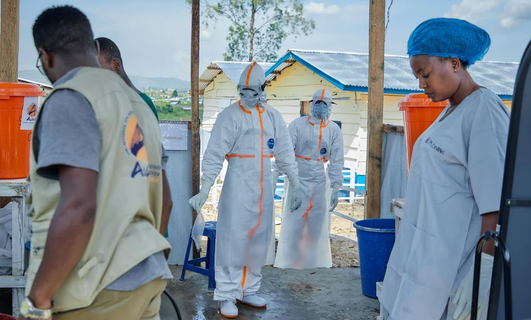 Ebola workers in white hazmat suits outside treatment center in DR Congo