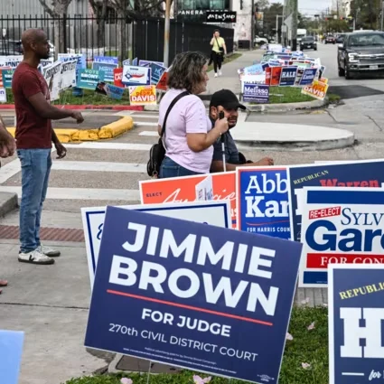 Houston, Texas, États-Unis. 03 mars 2026. Au premier jour des primaires au Texas, des habitants de Houston passent devant les affiches de campagnes de différents candidats.