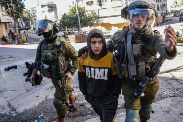 Des soldats israéliens arrêtent un jeune garçon lors de manifestations à Hébron, 2022. Israël a été accusé de recourir à des tactiques musclées.