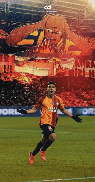 Football player celebrating victory on field with fiery mascot banner behind. — Galatasaray Picture