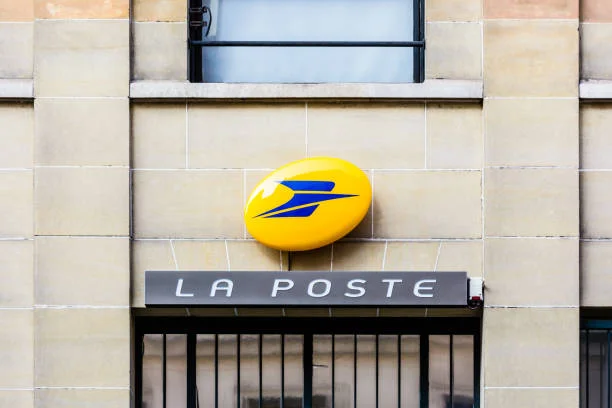 Sign of La Poste, the french postal service company, above the entrance of a post office. Paris, France - October 18, 2018: Front view of the sign of La Poste company, the french postal service public company, on the facade of a building above the entrance of a post office. la-poste stock pictures, royalty-free photos & images