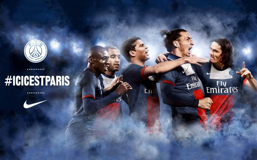 Paris Saint-Germain football players celebrating in blue smoke at night. — PSG Picture
