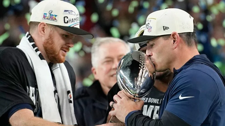 Seattle Seahawks head coach Mike MacDonald (R) and quarterback Sam Darnold with the Vince Lombardi Trophy after winning Super Bowl 60