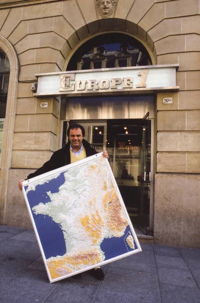Laurent Cabrol, 'Monsieur Météo' d'Europe 1, photographié avec la carte de la France devant les bureaux de la radio, à Paris, France le 28 avril 1986.