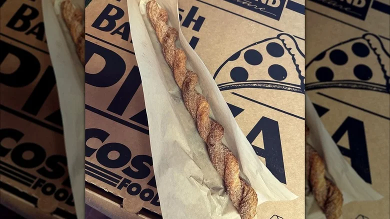 One twisted churro from Costco on top of a Costco pizza box