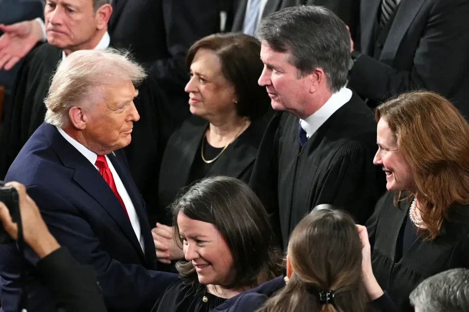 President Donald Trump shakes hands with Supreme Court Justice Amy Coney Barrett as he arrives to deliver the State of the Union address.