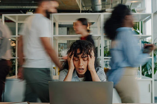 femme d’affaires stressée tenant la tête dans un bureau occupé - etre sous tension photos et images de collection